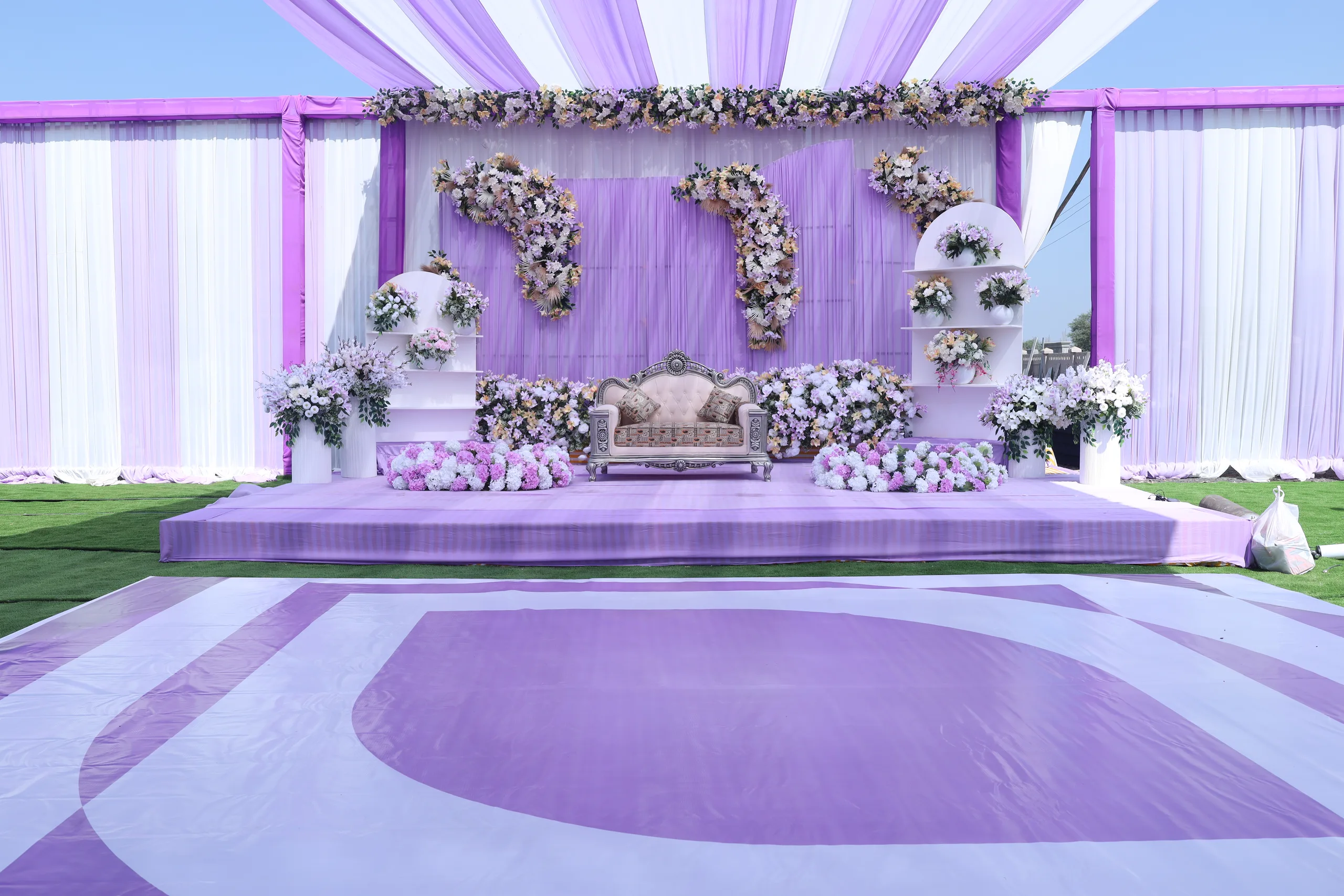 Wedding mandap at Vetiver Grand, Jabalpur: floral backdrop and ornate silver loveseat on the dressed stage.