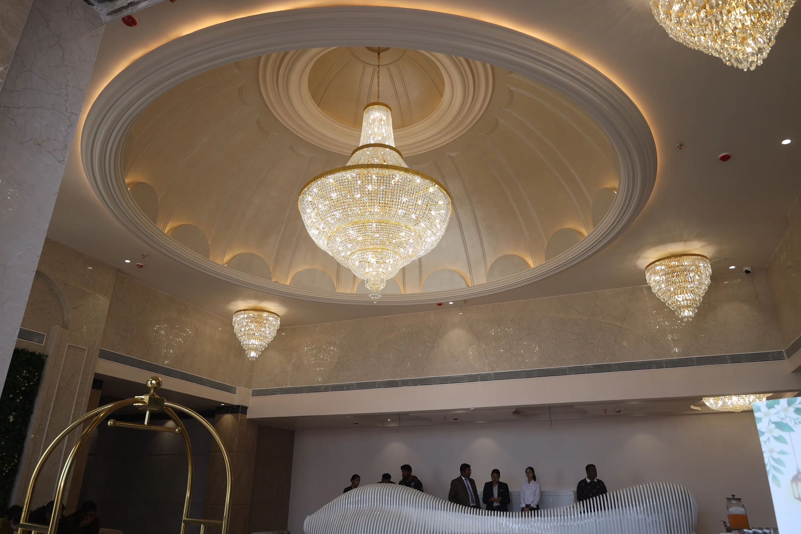 The domed lobby at Vetiver Grand, Jabalpur: crystal chandelier under a coffered dome, where delegates check in.
