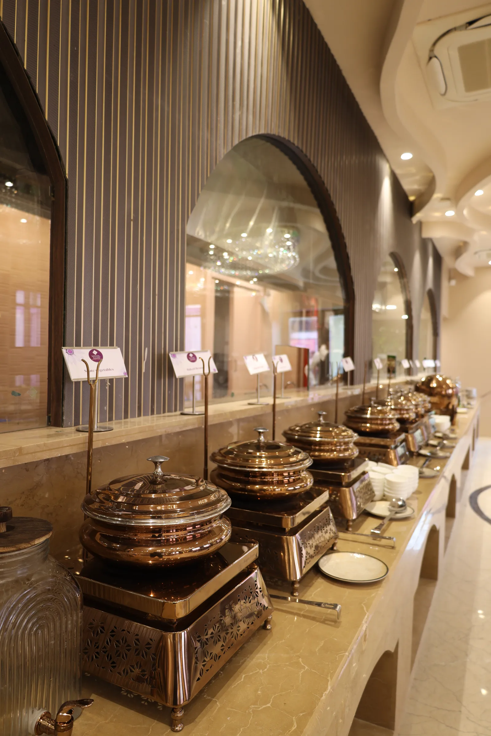 Copper service: a line of polished chafing dishes under the arched buffet colonnade at Kasturi.